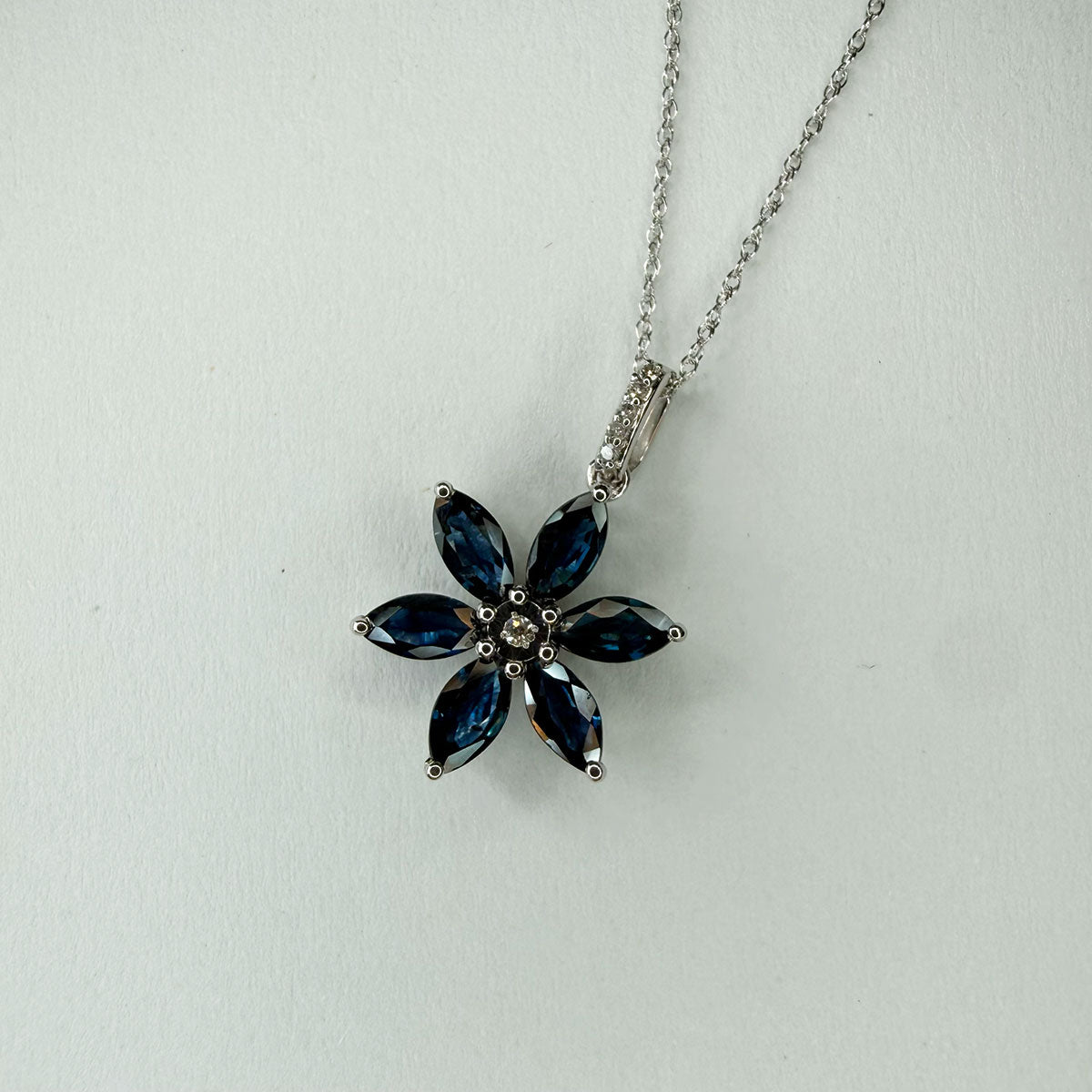 Collar flor de seis pétalos con zafiros en oro blanco 10k