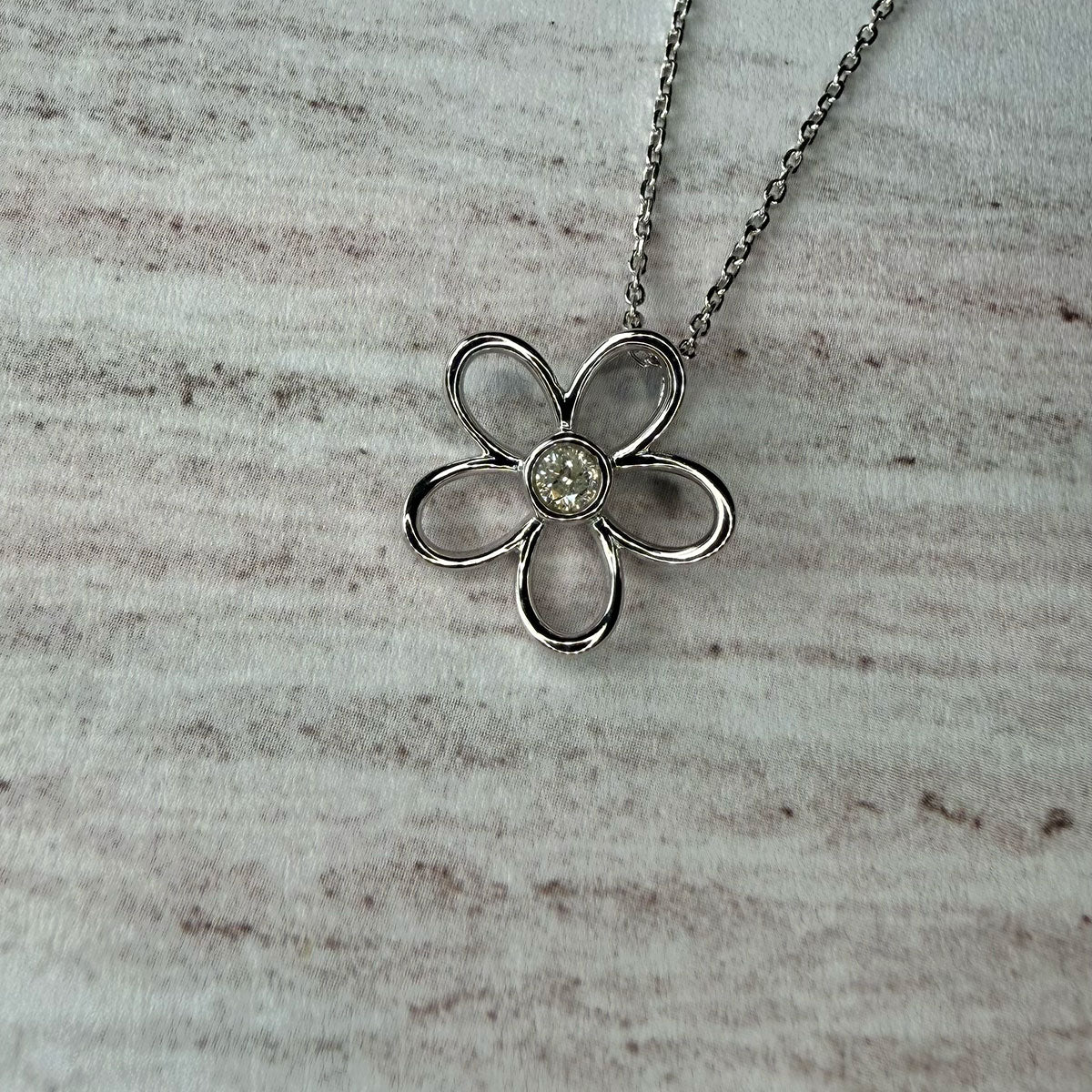 Collar flor delinada con diamante 0.10ct en el centro en plata