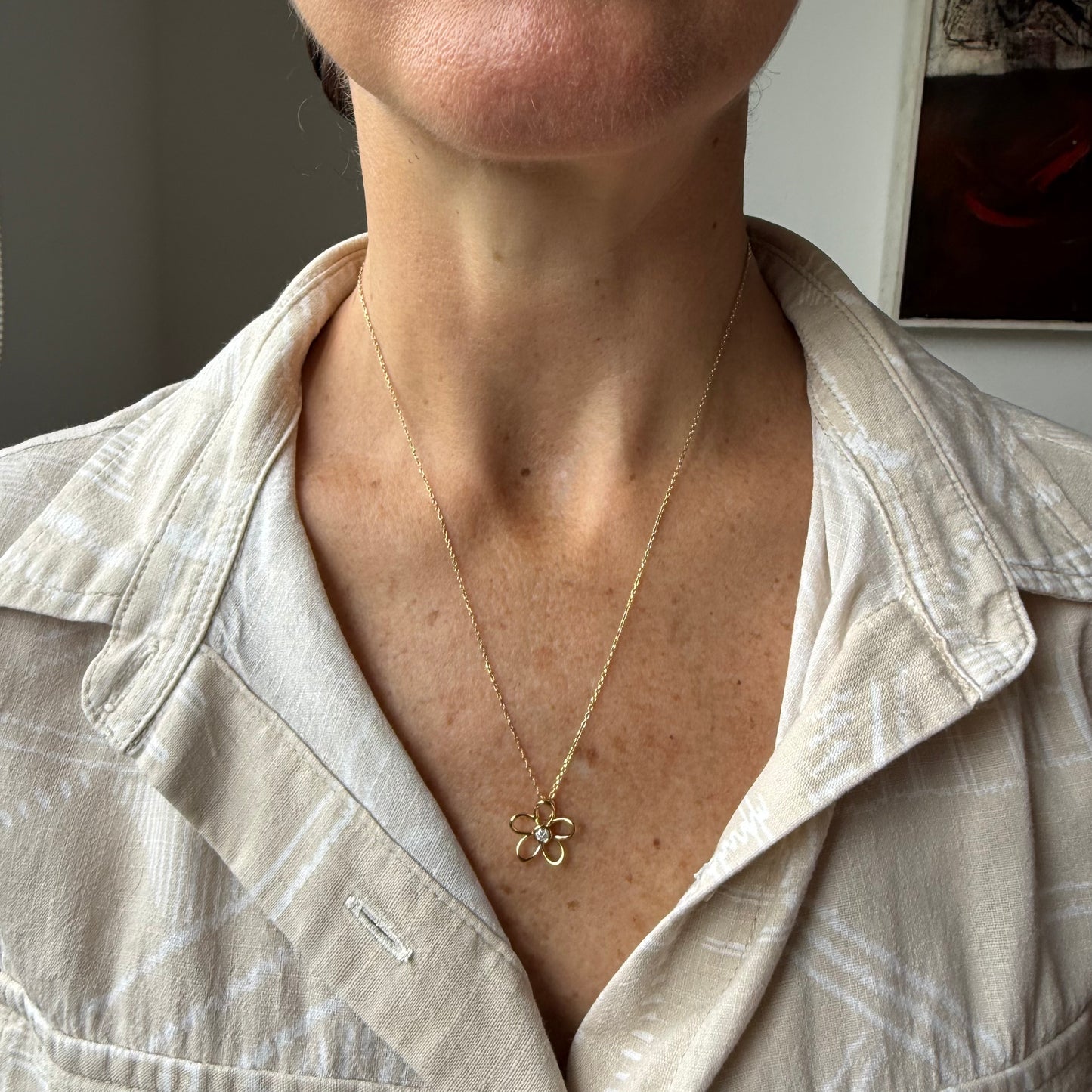 Collar flor delinada con diamante 0.10ct en el centro en plata con baño de oro amarillo