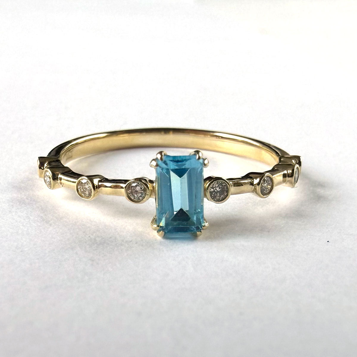 Anillo en oro amarillo 10K con topacio corte esmeralda y diamantes 0.10ctw