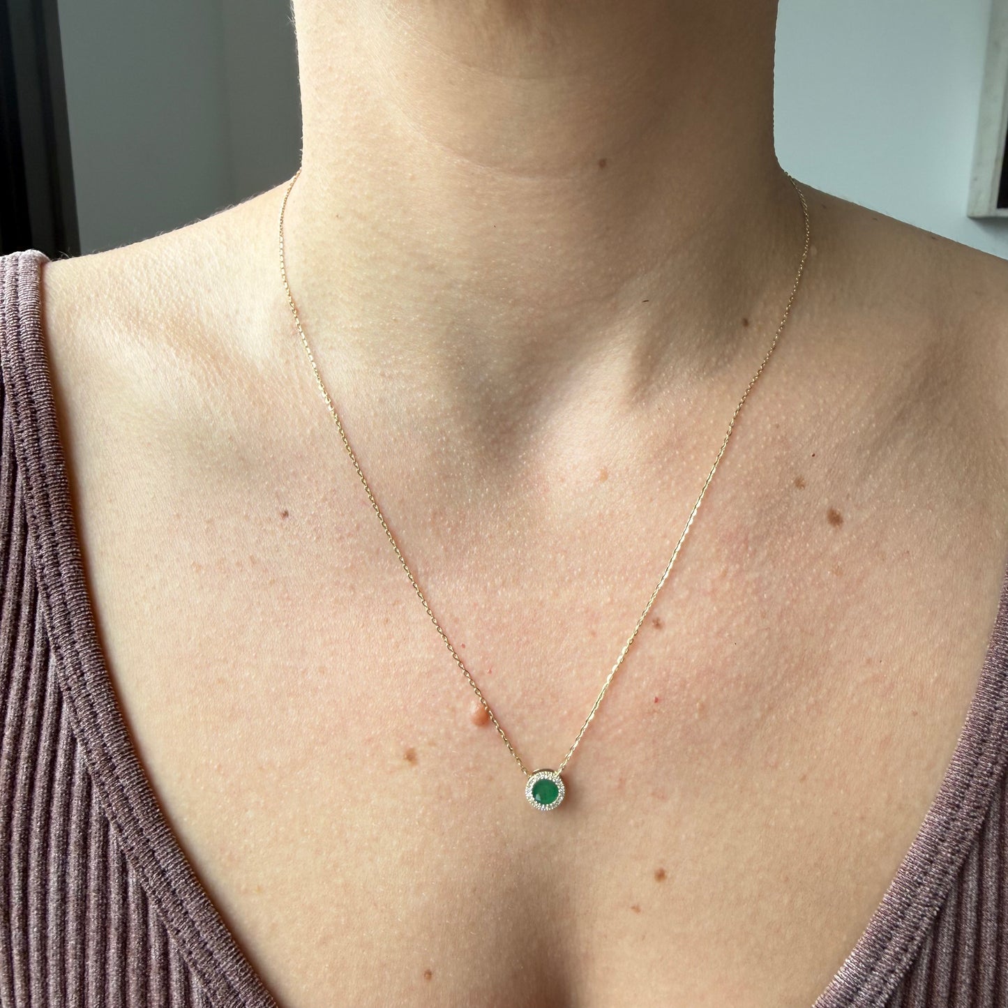 Collar en oro amarillo 14k con esmeralda redonda y halo de diamantes 0.06ctw