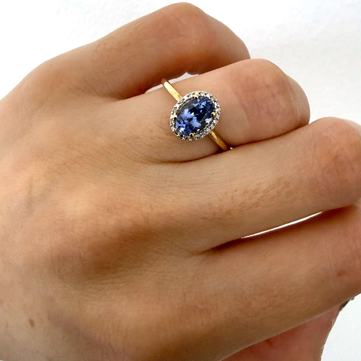 Anillo de oro amarillo 10k con tanzanita ovalada y halo de diamantes