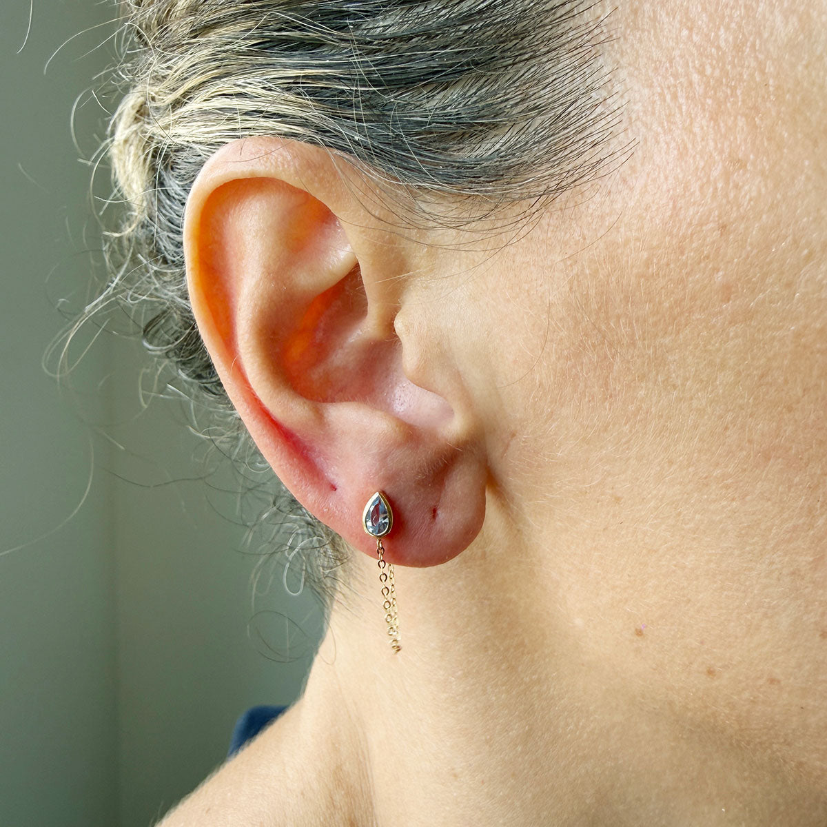 Arete en oro amarillo 14k con circonita gota celeste con cadena