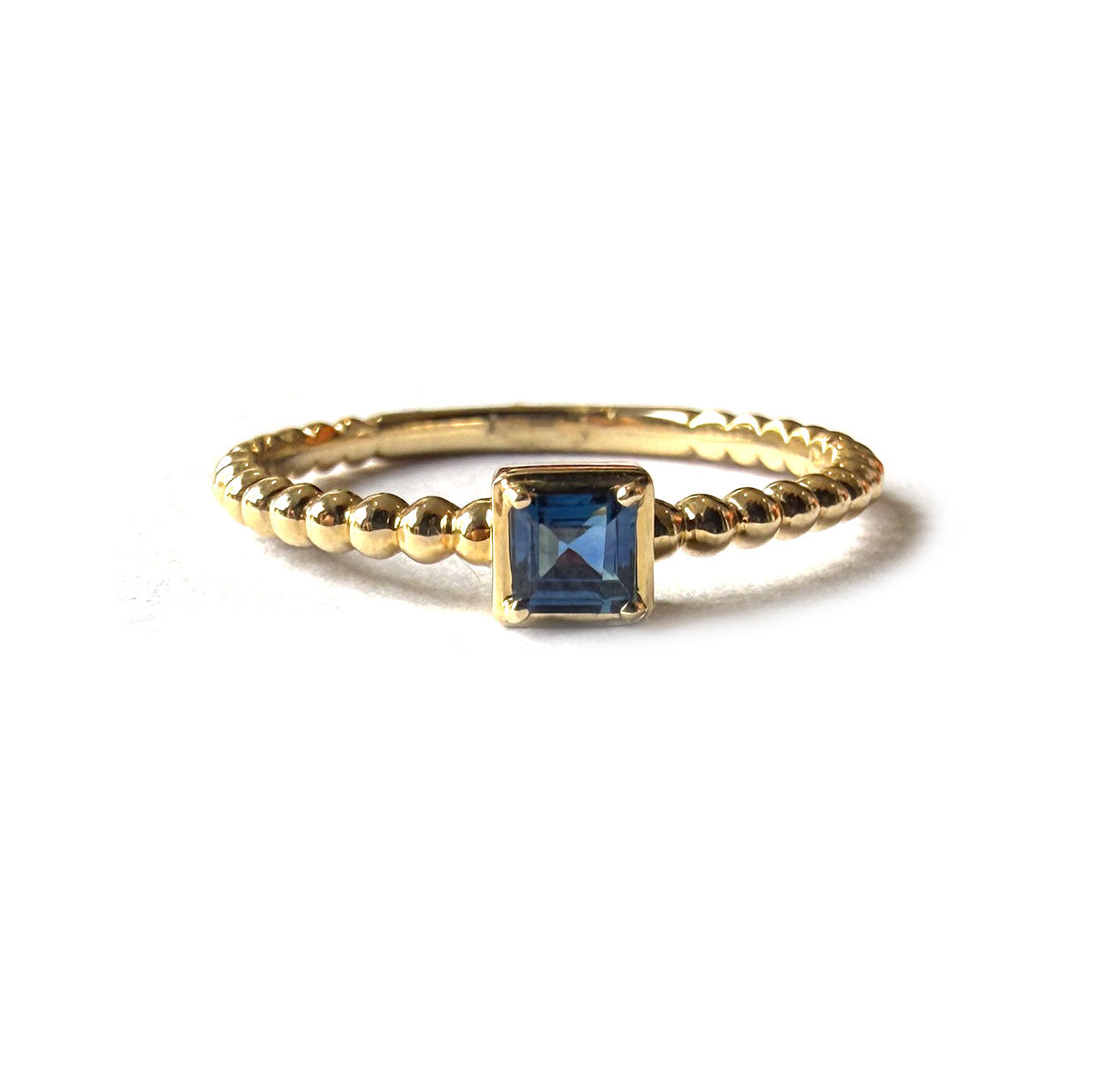 Anillo en oro amarillo 14k con aro de bolitas y zafiro cuadrado 0.25ct