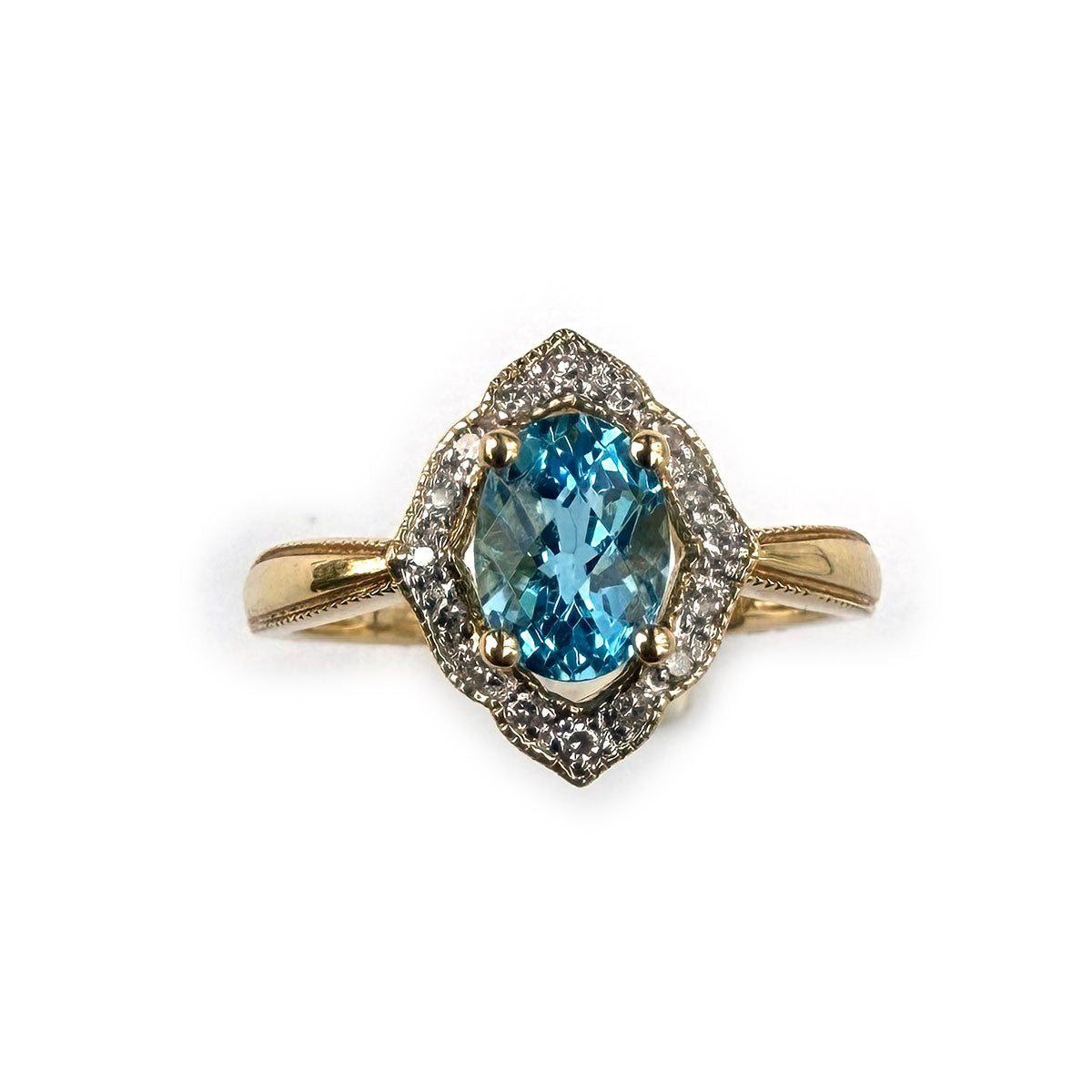 Anillo en oro amarillo 14K con topacio azul ovalado y borde de diamantes 0.10ctw