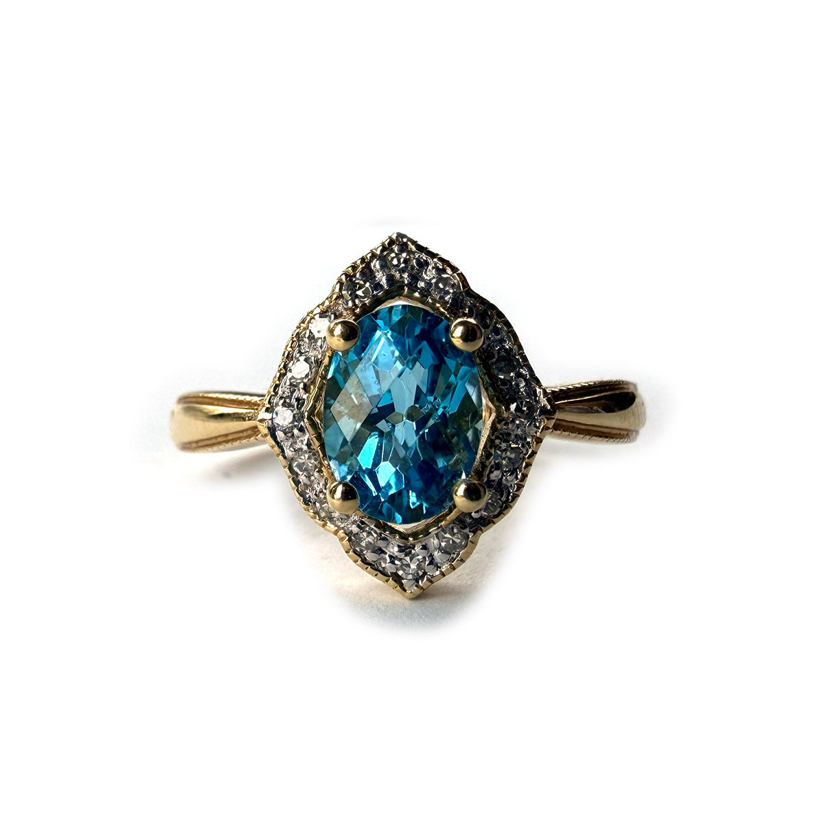 Anillo en oro amarillo 14K con topacio azul ovalado y borde de diamantes 0.10ctw
