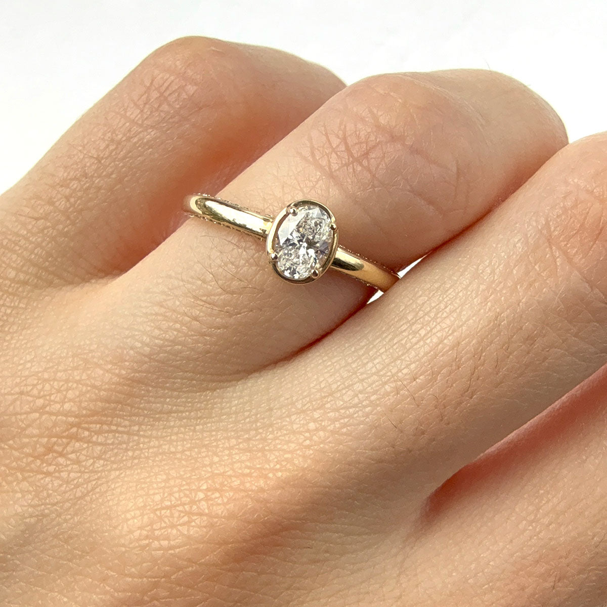 Anillo en oro amarillo 14K con diamante ovalado y diamantes en el aro 0.50ctw