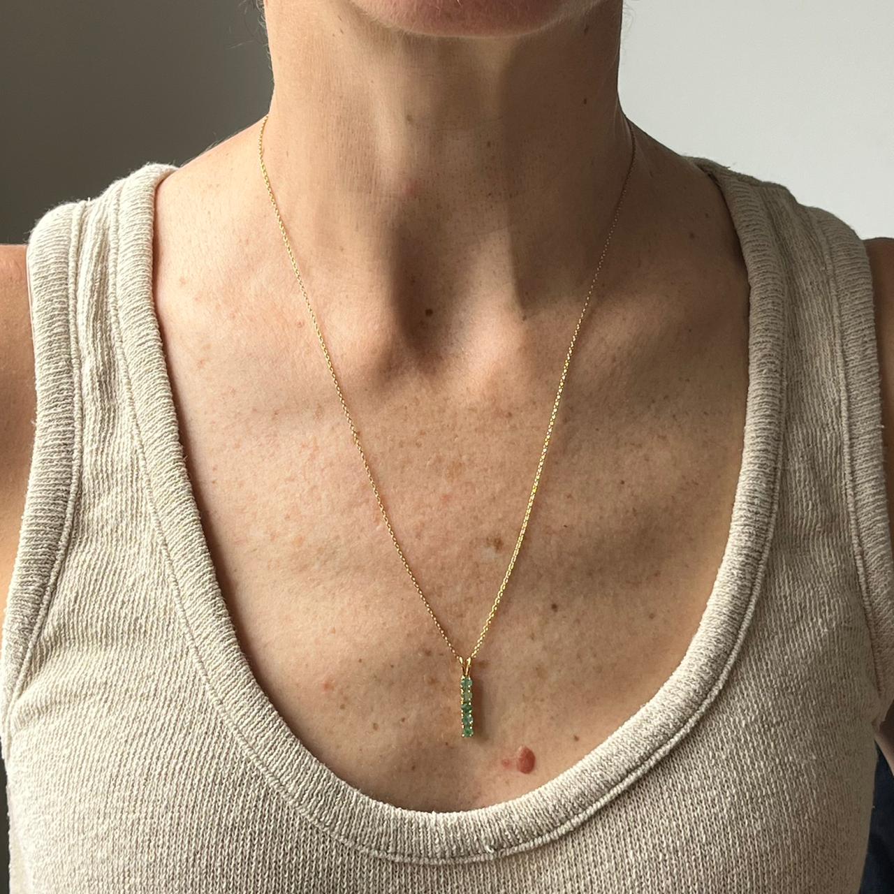 Collar de plata con baño de oro amarillo y esmeraldas redondas en fila