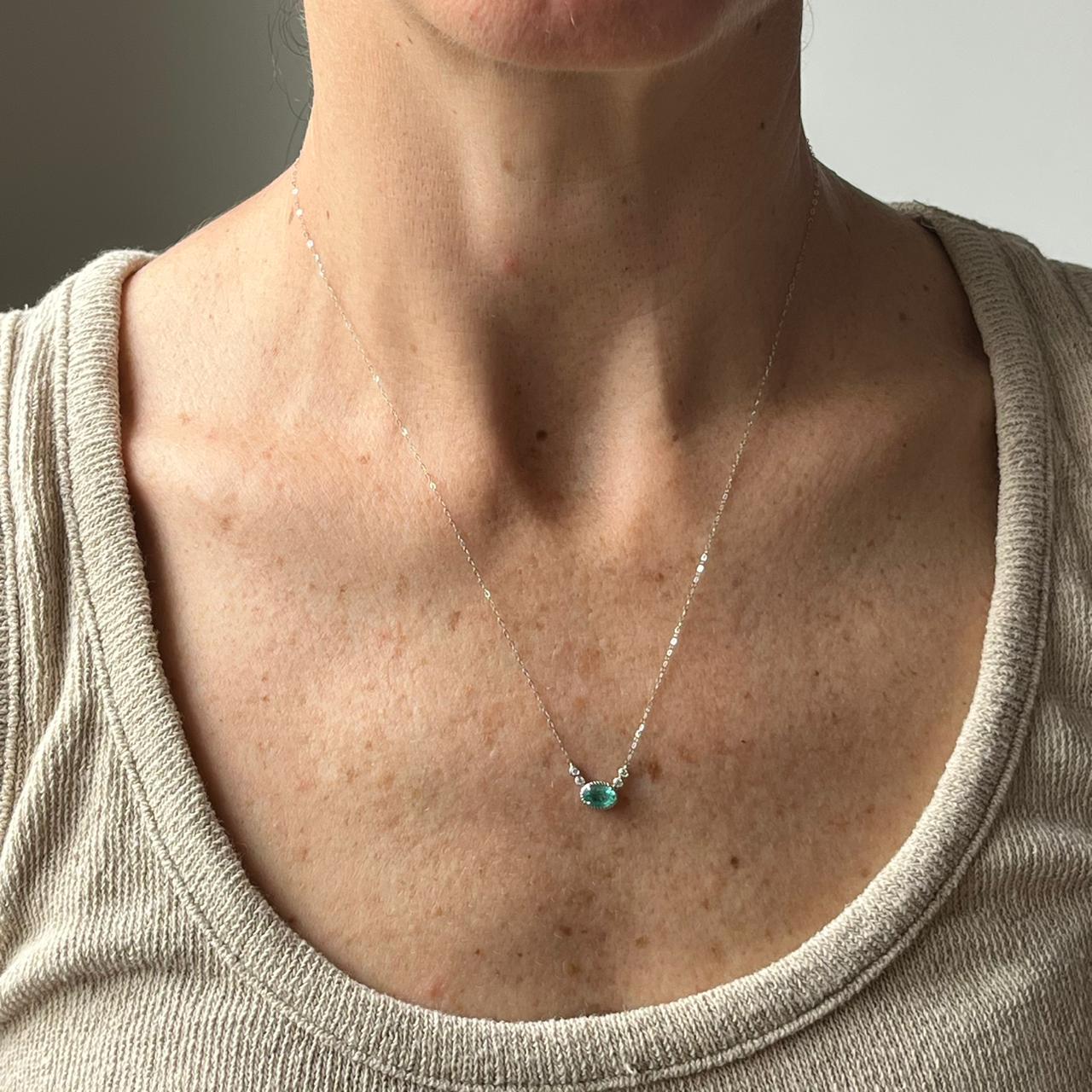 Collar en oro blanco 14K con esmeralda ovalada y diamantes biselados