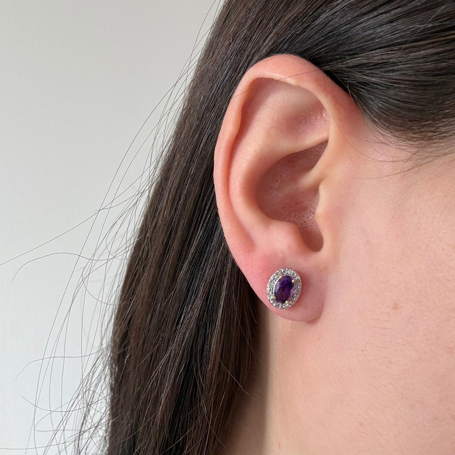 Aretes en oro amarillo 10K con amatista ovalada y halo de diamantes 0.09ctw