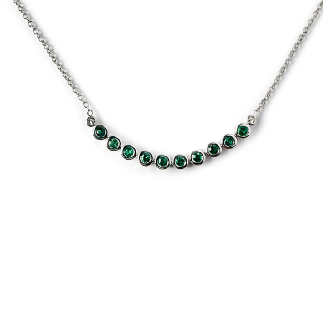 Collar en oro blanco 10k con curva de esmeraldas biseladas