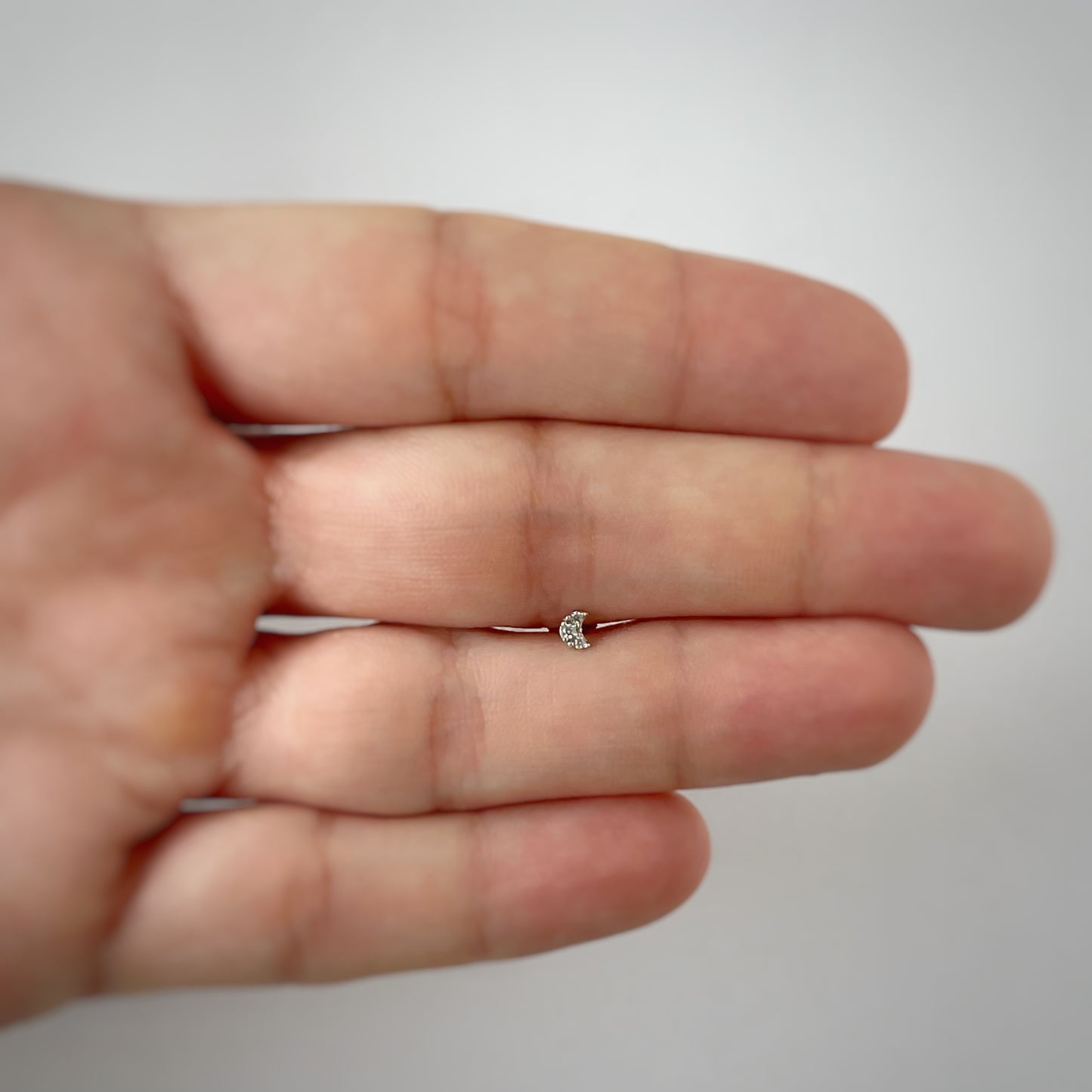 Arete piercing single media luna mini con circonita en oro blanco de 14k