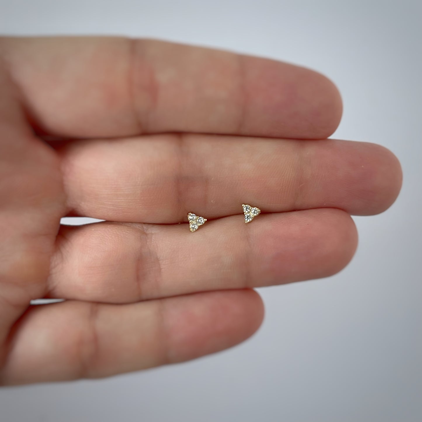 Aretes tres circonitas blancas mini en oro de 14k con tope ortopédico