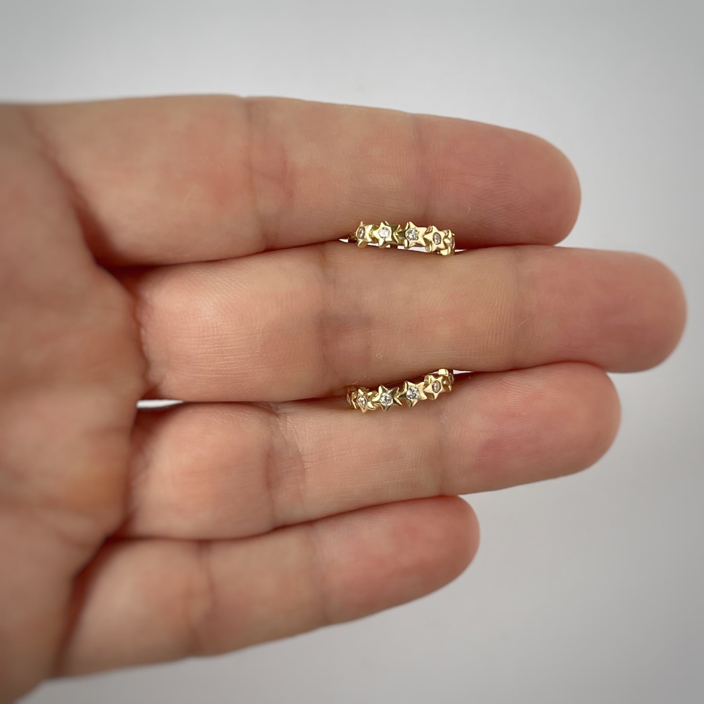 Argollas mini con circonitas blancas de estrellas en oro de 14k