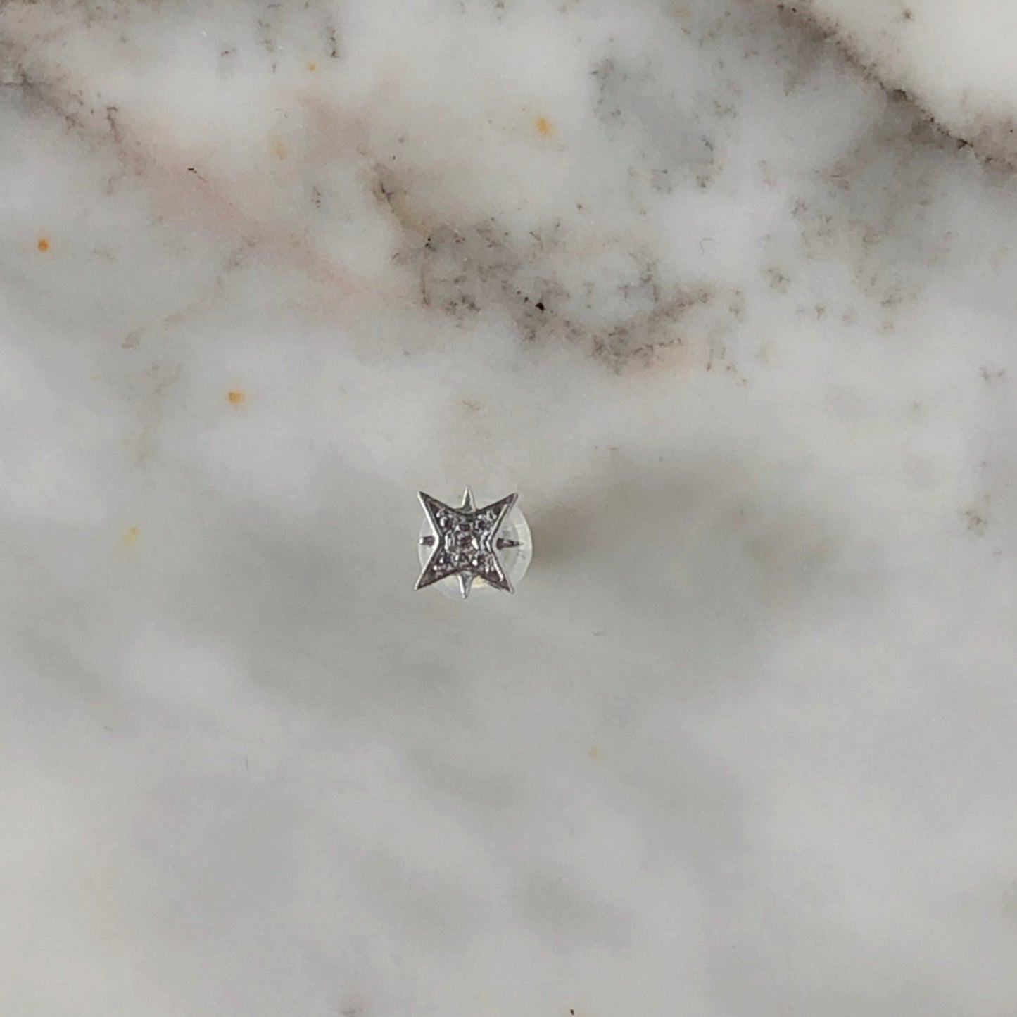 Arete single estrella polar con circonitas en oro blanco de 14k