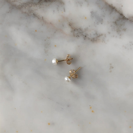 Arete de media perla en oro amarillo de 14k con mariposa