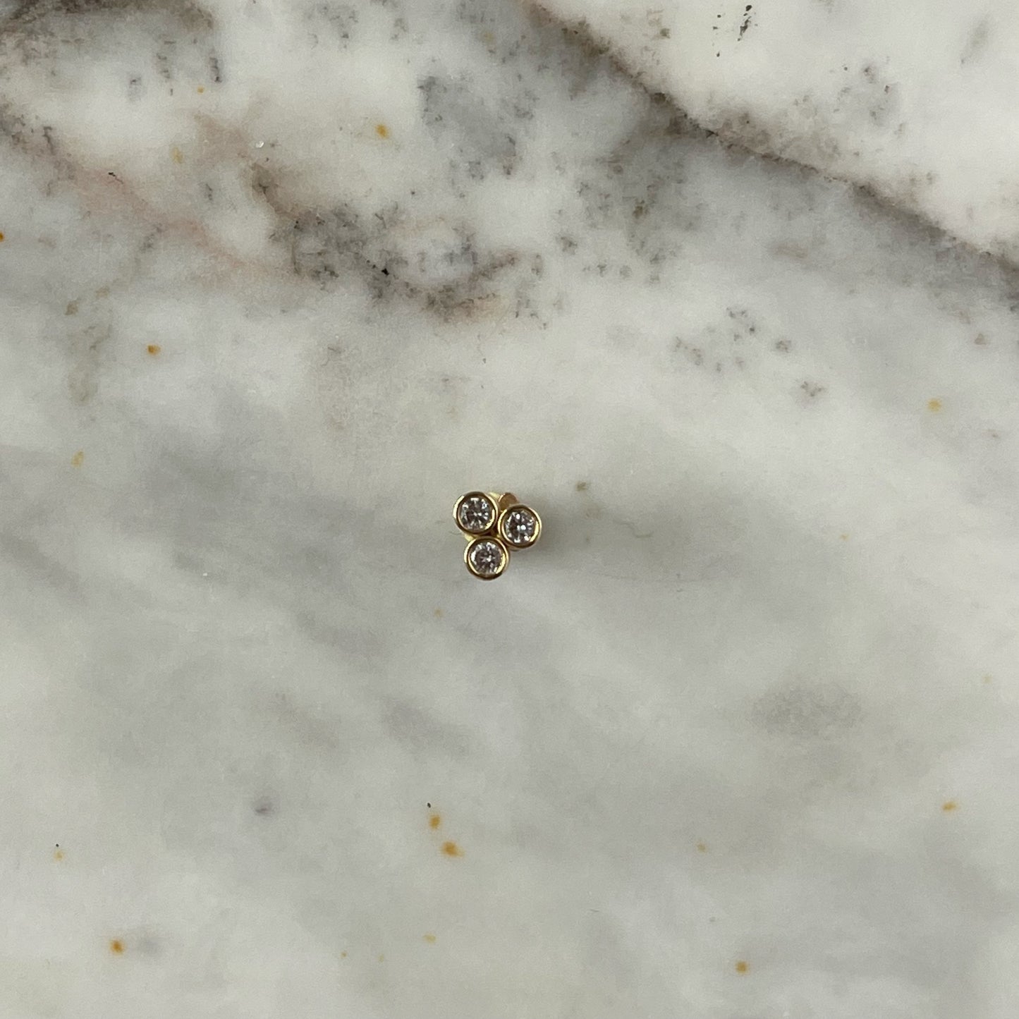 Arete piercing single de 3 circonitas biseladas en oro amarillo de 14 k
